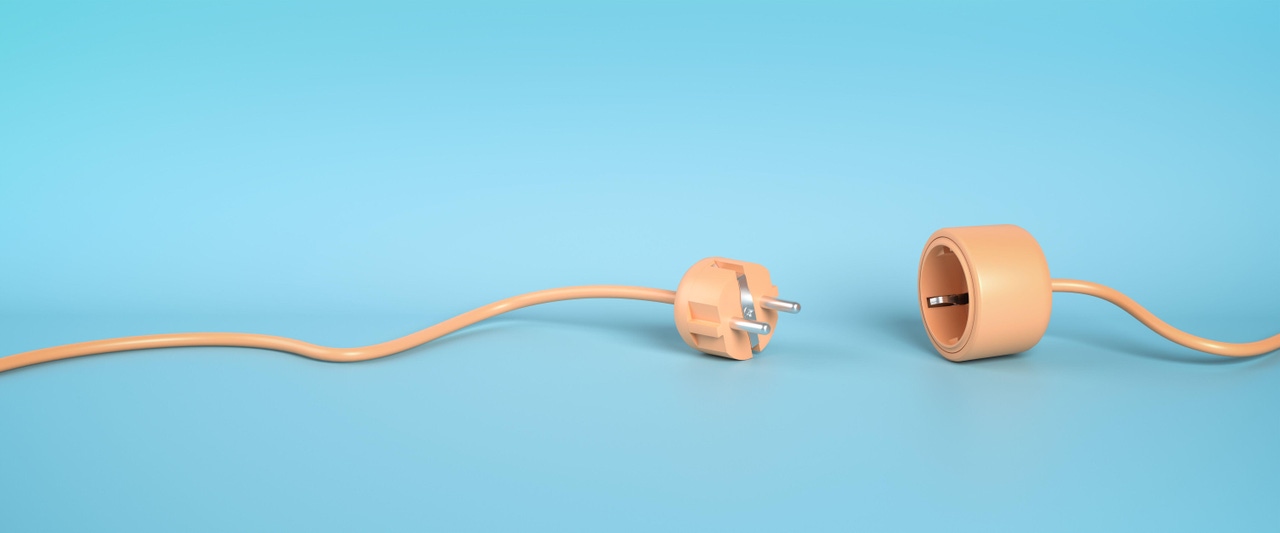 plug and socket unattached. peach-colored wire lying unplugged on light blue background 